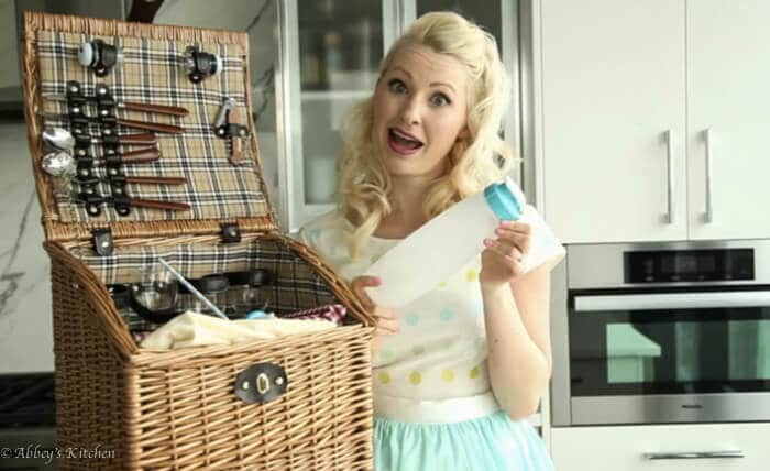 Abbey Sharp packing a picnic basket, holding a bottle.