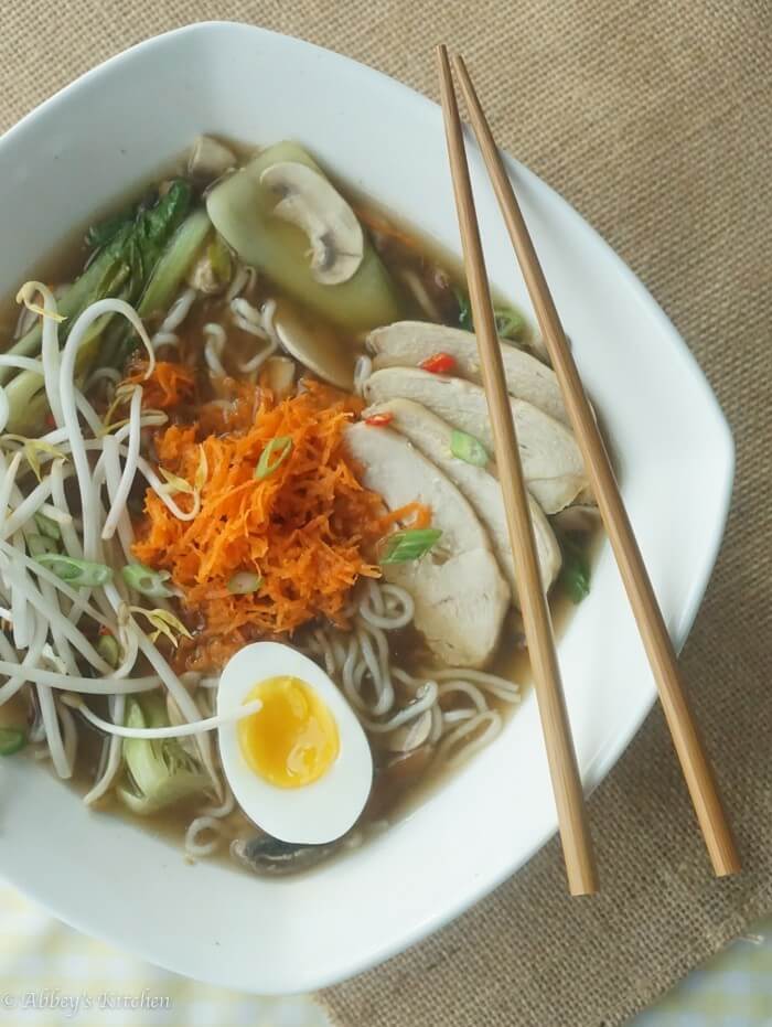 bids eye view of gluten free chicken ramen in a white bowl with chopsticks