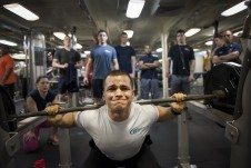 A man squatting with weights.