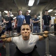 A man squatting with weights.