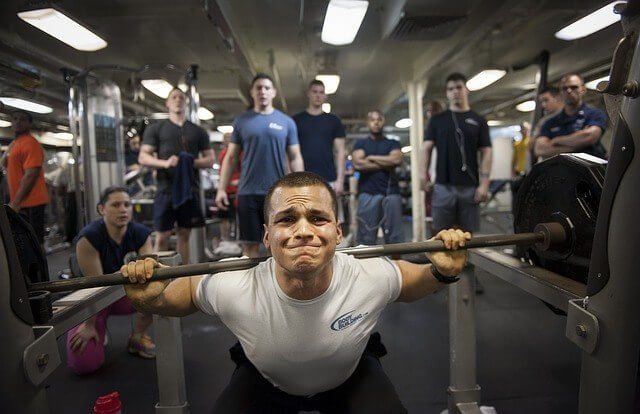 A man squatting with weights.