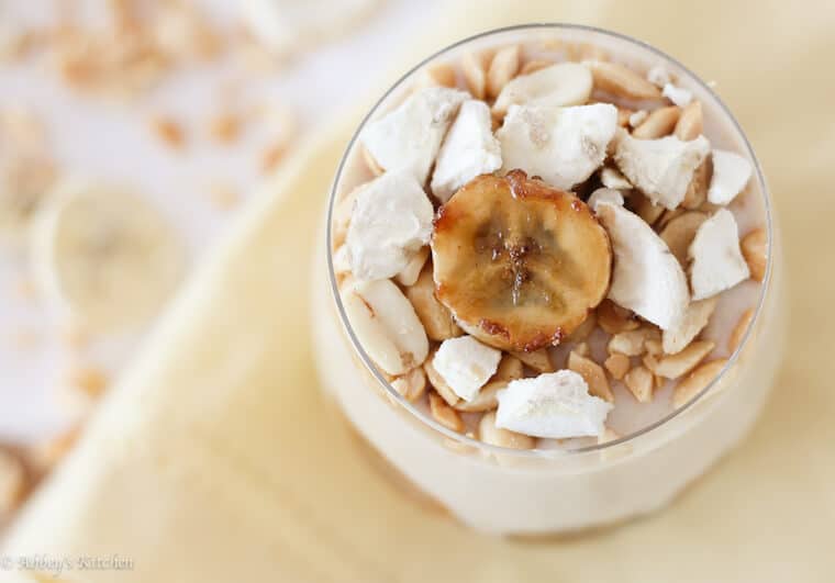 An overhead photo of a glass of banana protein pudding with banana garnished on top.