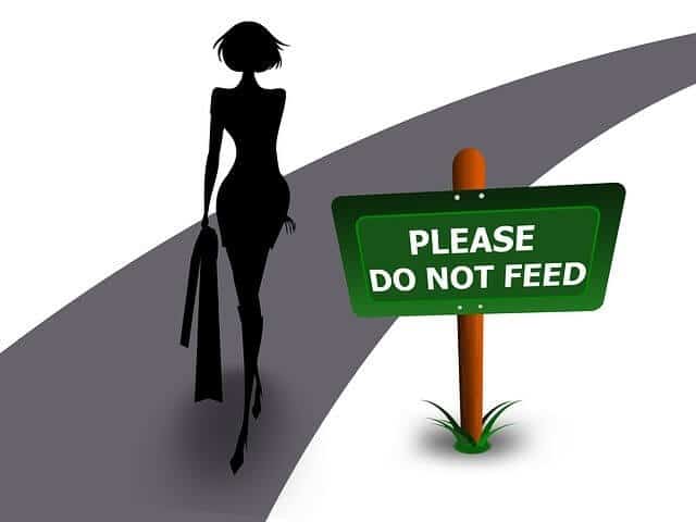 A cartoon of a woman beside a sign \"Please Do Not Feed.\"