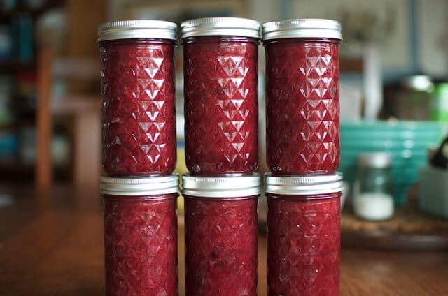 Six mason jars of cherry rhubarb jam.