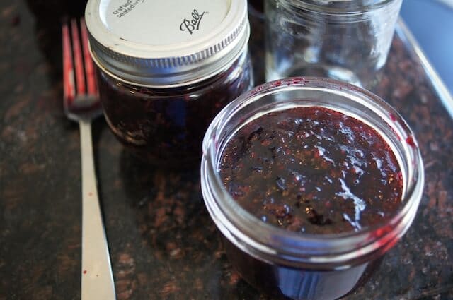 An opened mason jar of homemade jam.