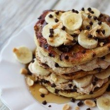 A stack of peanut butter banana protein pancakes with banana slices on top.