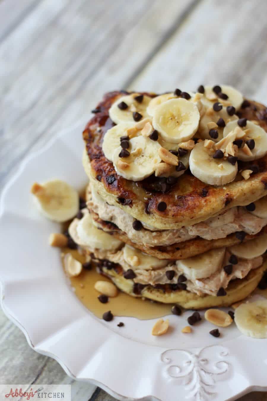 A stack of peanut butter banana protein pancakes with banana slices on top.