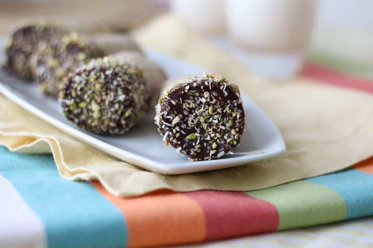 Close up photo of a plate of the chocolate dipped part of banana roll ups on a stick.