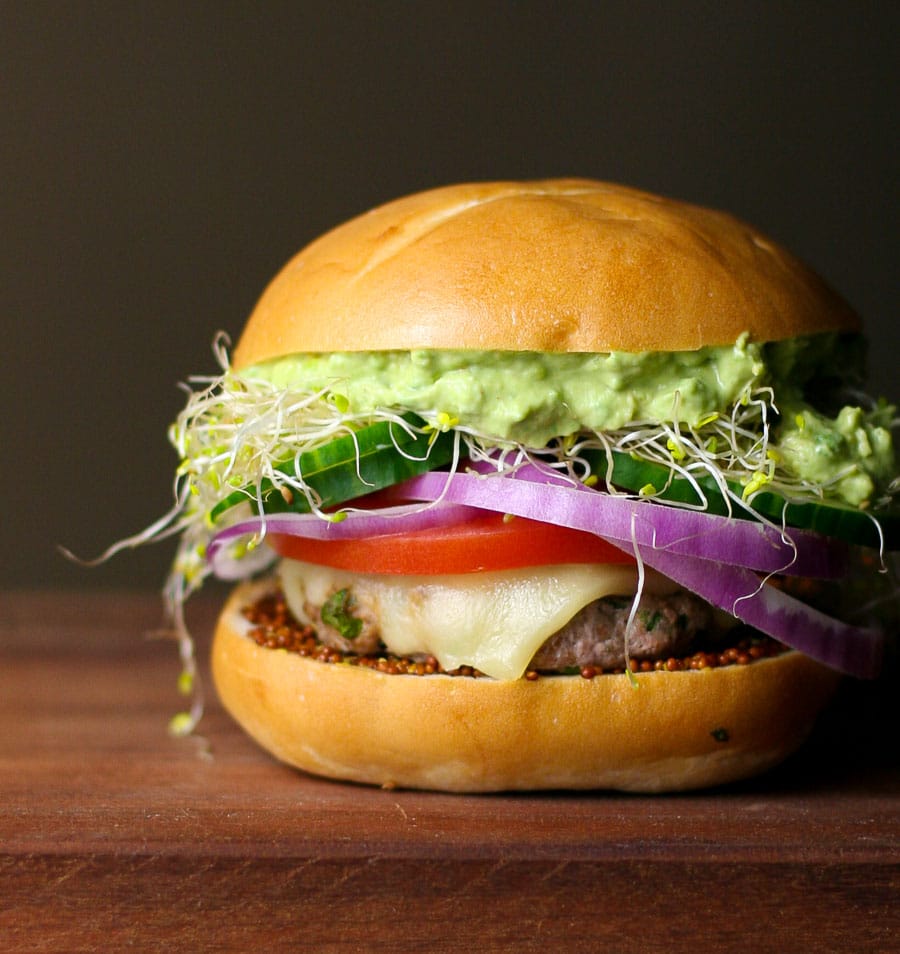 A california turkey burger with melted cheese, guacamole, tomatoes, and red onions.