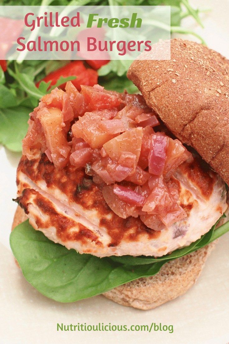 A grilled salmon burger with lettuce underneath. 