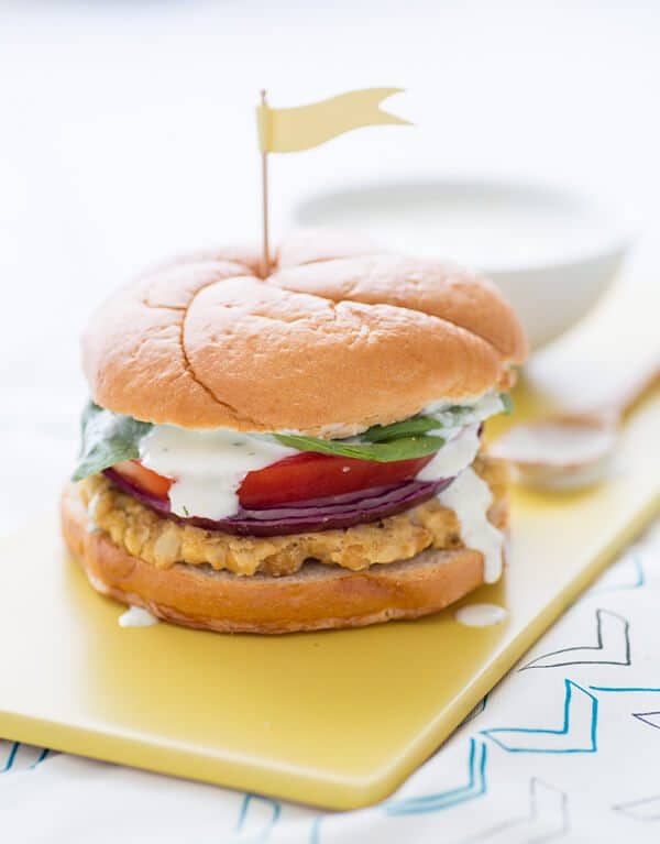 A cauliflower hummus burger with a little flag toothpick on top.