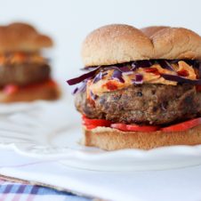 A close up of a hummus burger on a white plate.