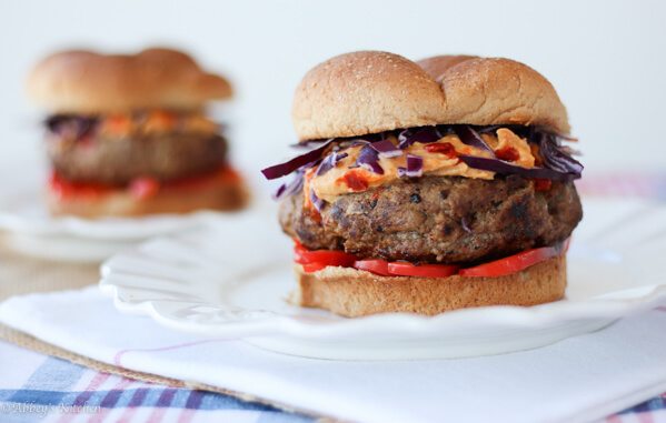 A close up of a hummus burger on a white plate.