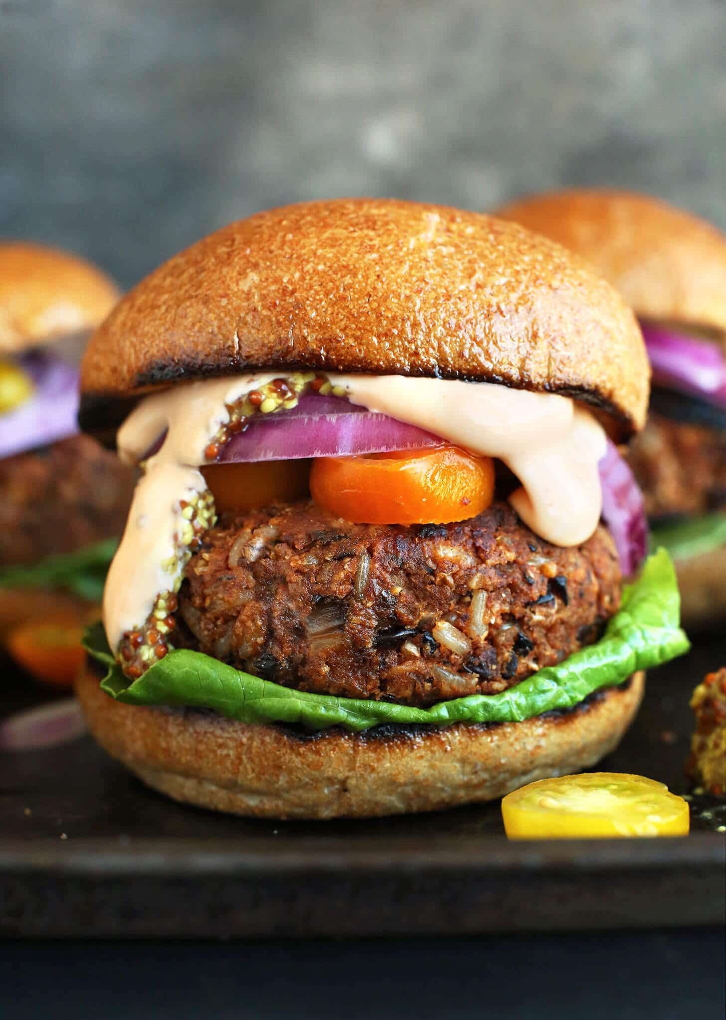 A close up of a veggie burger with melty cheese.