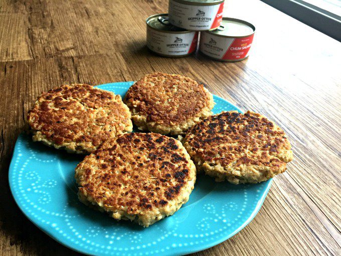 A blue plate with four salmon patties.