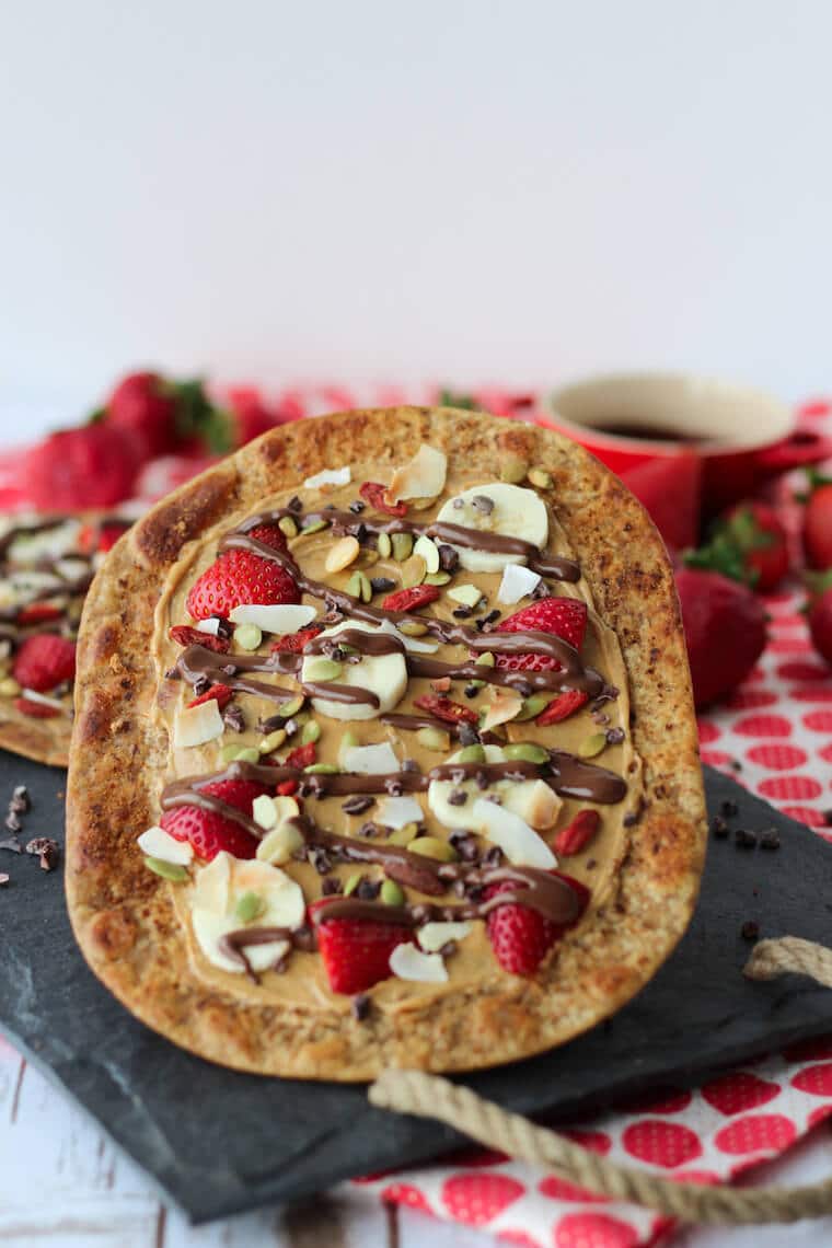 A beaver tail made out of flatbread with strawberries and bananas on top.