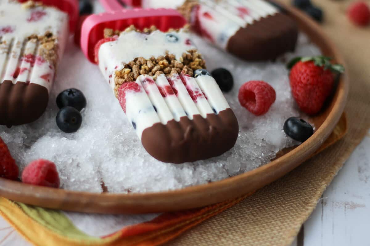 A close up of healthy popsicles on a plate of ice.