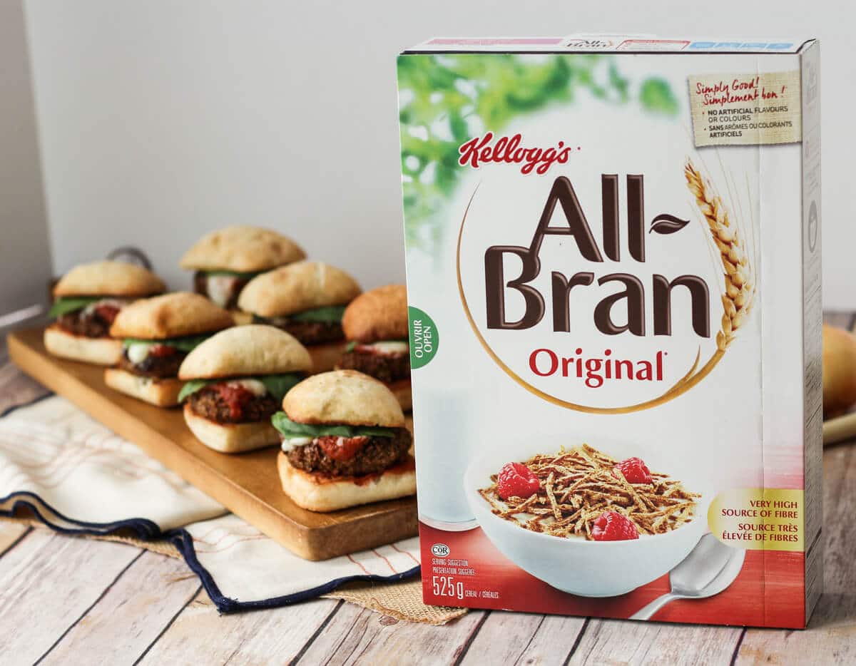 A box of All-Bran cereal in front of chicken sliders in the background.