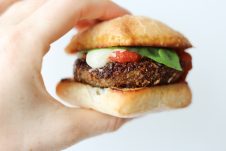 A hand holding a chicken parmesan slider.