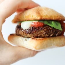 A hand holding a chicken parmesan slider.