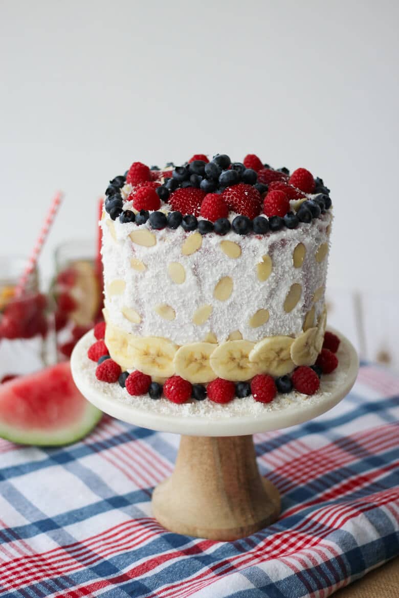 watermelon cake topped with berries on a serving dish.