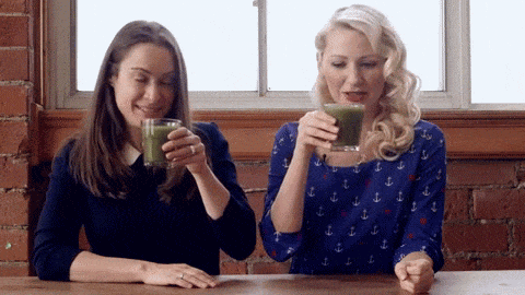 A gif of Abbey Sharp and Abby Langer drinking a shake.