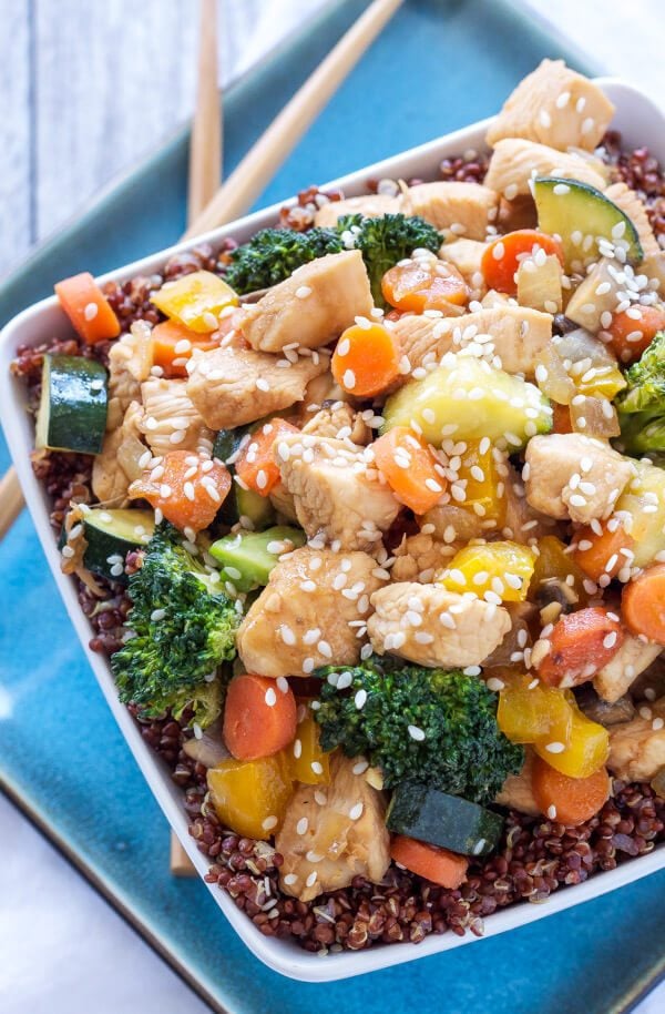 A plate of chicken and vegetable stir fry quinoa bowl.