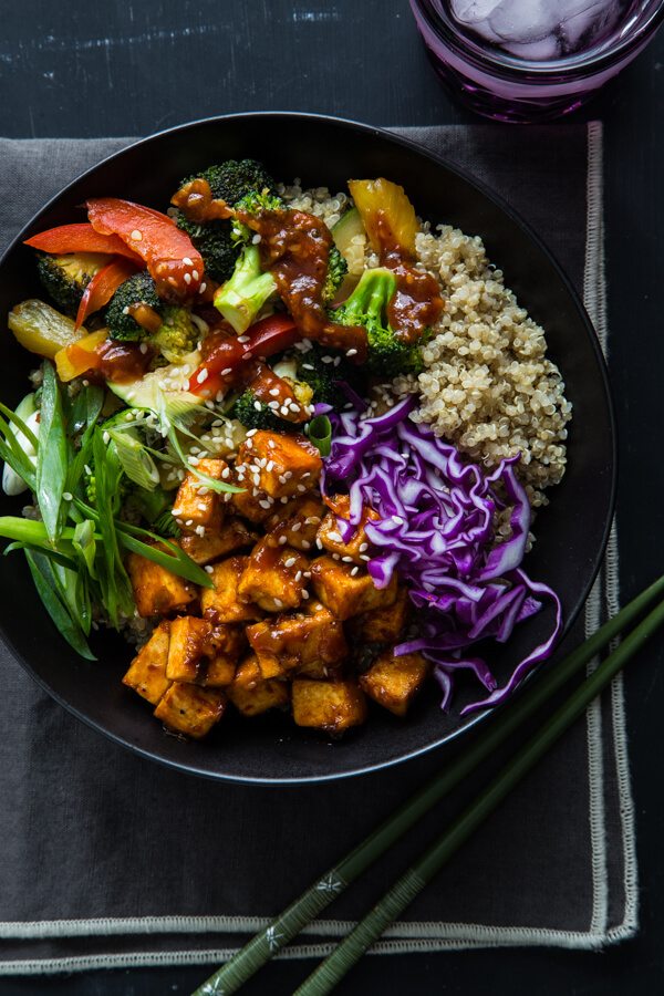 A bowl with korean barbecue tofu bowl with stir fried vegetables and quinoa.