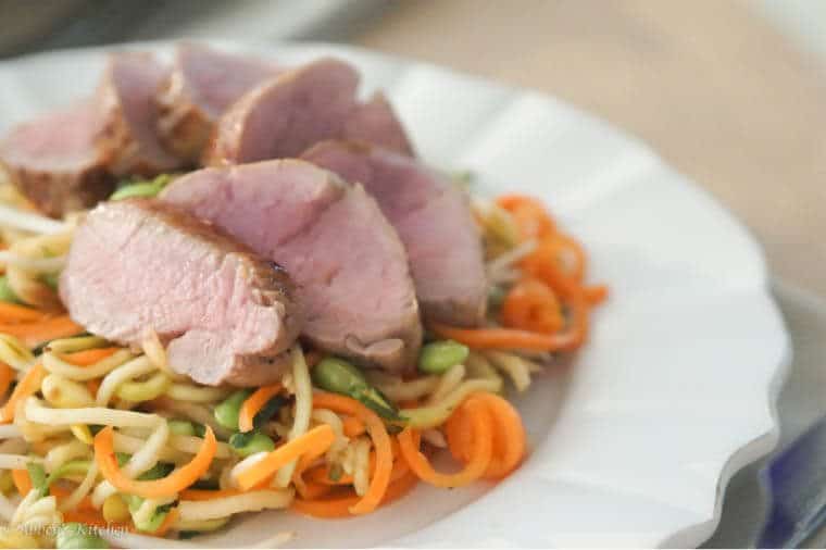 A close up of a plate of noodles with meat on top.