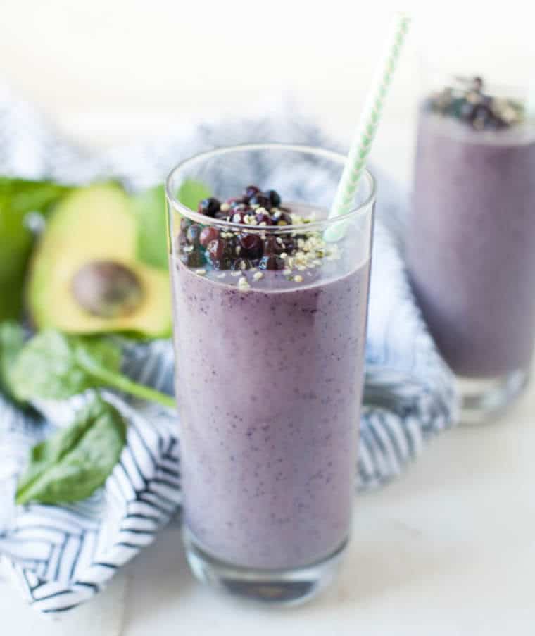 a glass of smoothie with a straw inside.