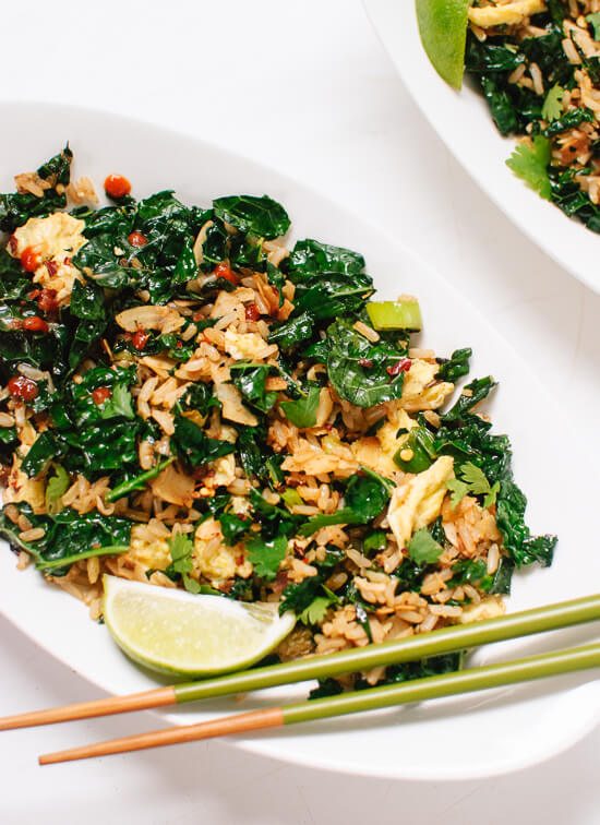 A white plate with spicy kale and coconut stir fry.