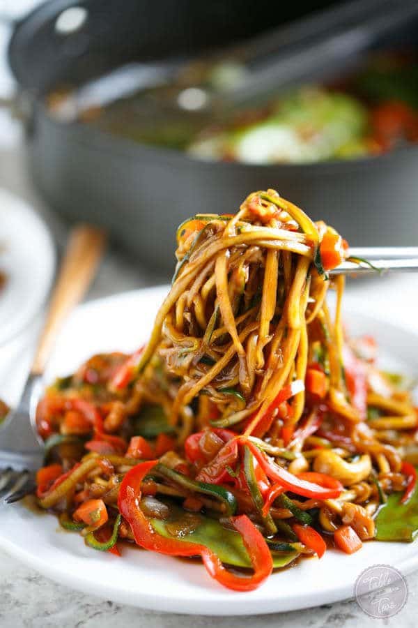 A plate with a cashew stir fry made with zoodles.