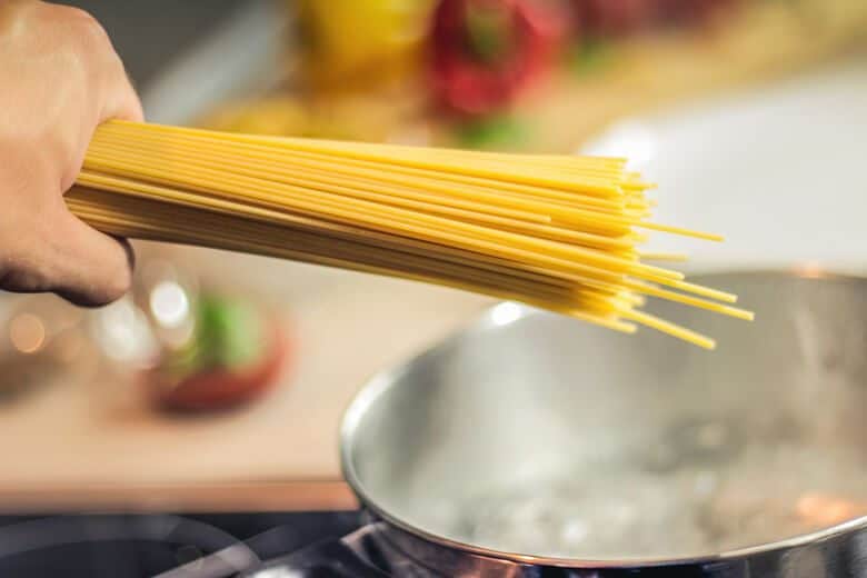 Pasta being added to a pot of boiling water.