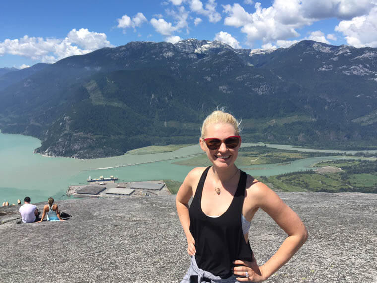 Abbey standing in front of a mountain view in work out clothes.