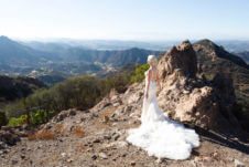 A view of a rocky mountain with Abbey Sharp in a wedding dress standing in front.