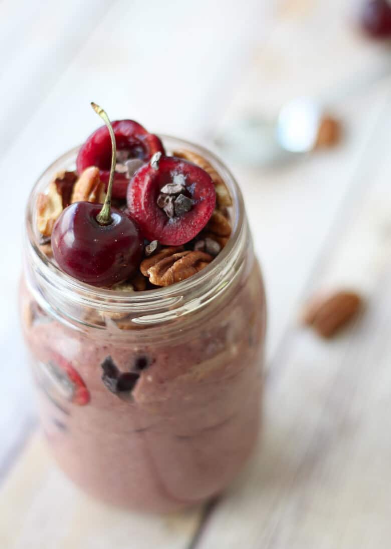 close up of vegan and gluten free cherry overnight oats topped with fresh cherries