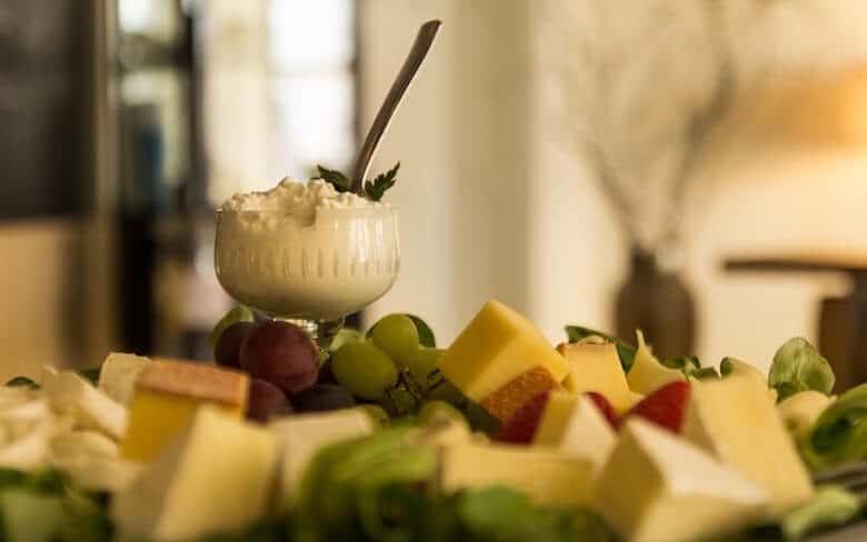 A bowl of cottage cheese by some fruit.