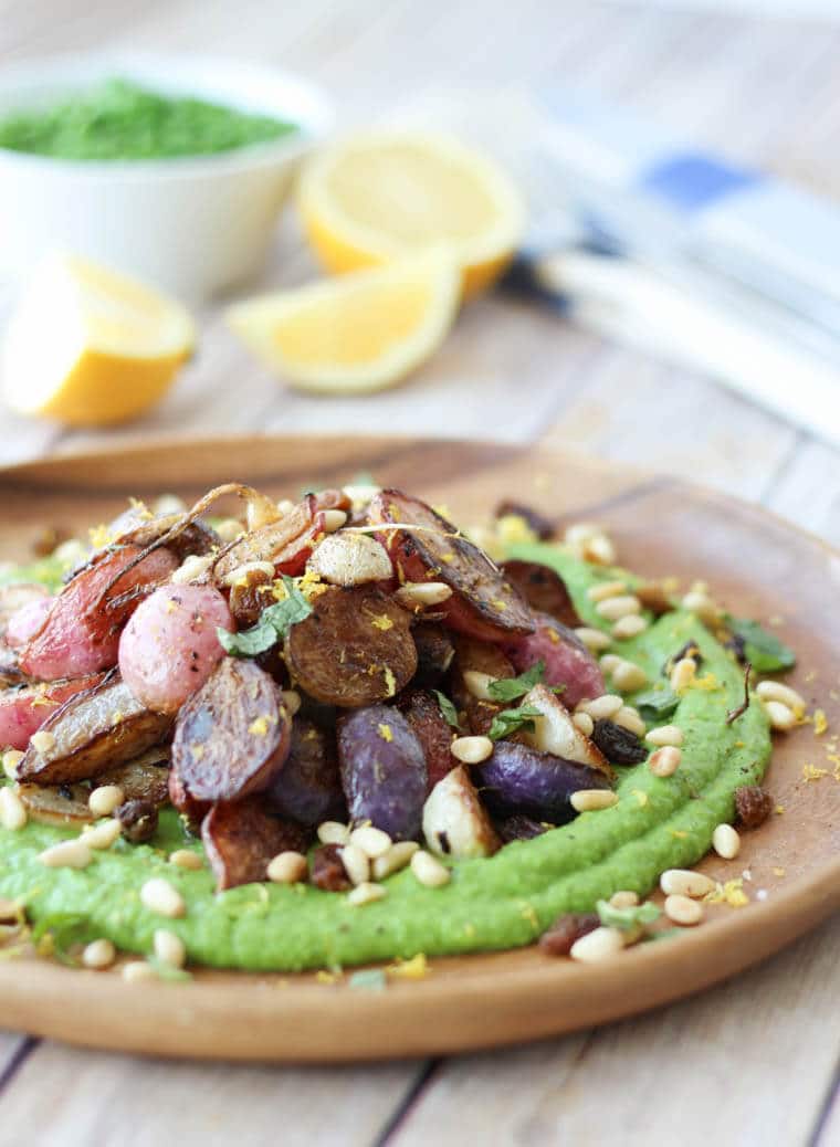 A close up of a plate of za\'atar roasted radishes over top of a pea puree.