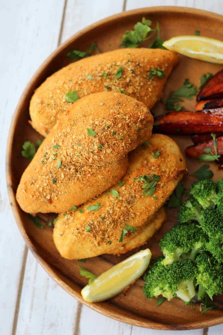 An close up photo of a brown plate with shake and bake chicken breasts.