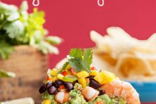 This Gluten Free Shrimp Taco Dip is layered with Guacamole, Mango Salsa and a fresh Mexican Bean Salad. It's the perfect cool shareable dish for Summer entertaining by the pool or BBQ.