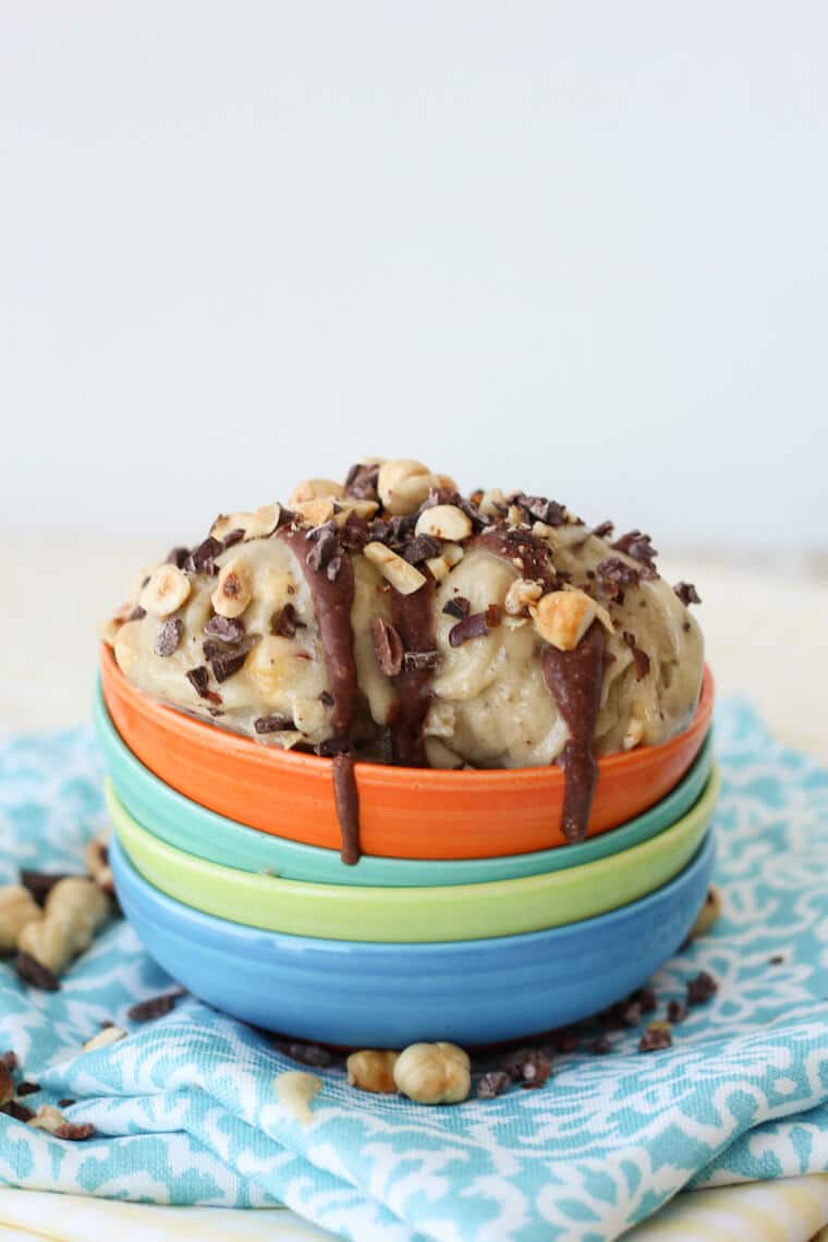 Multiple bowls stacked with three scoops of nutella banana ice cream on top.