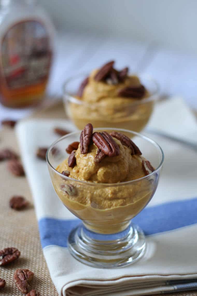 A close up of a pumpkin parfait with pecans on top.