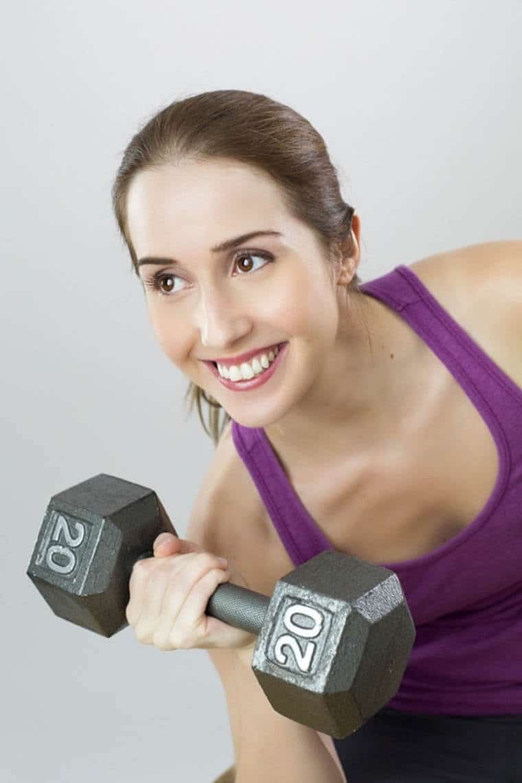 A woman holding a 20lb weight.