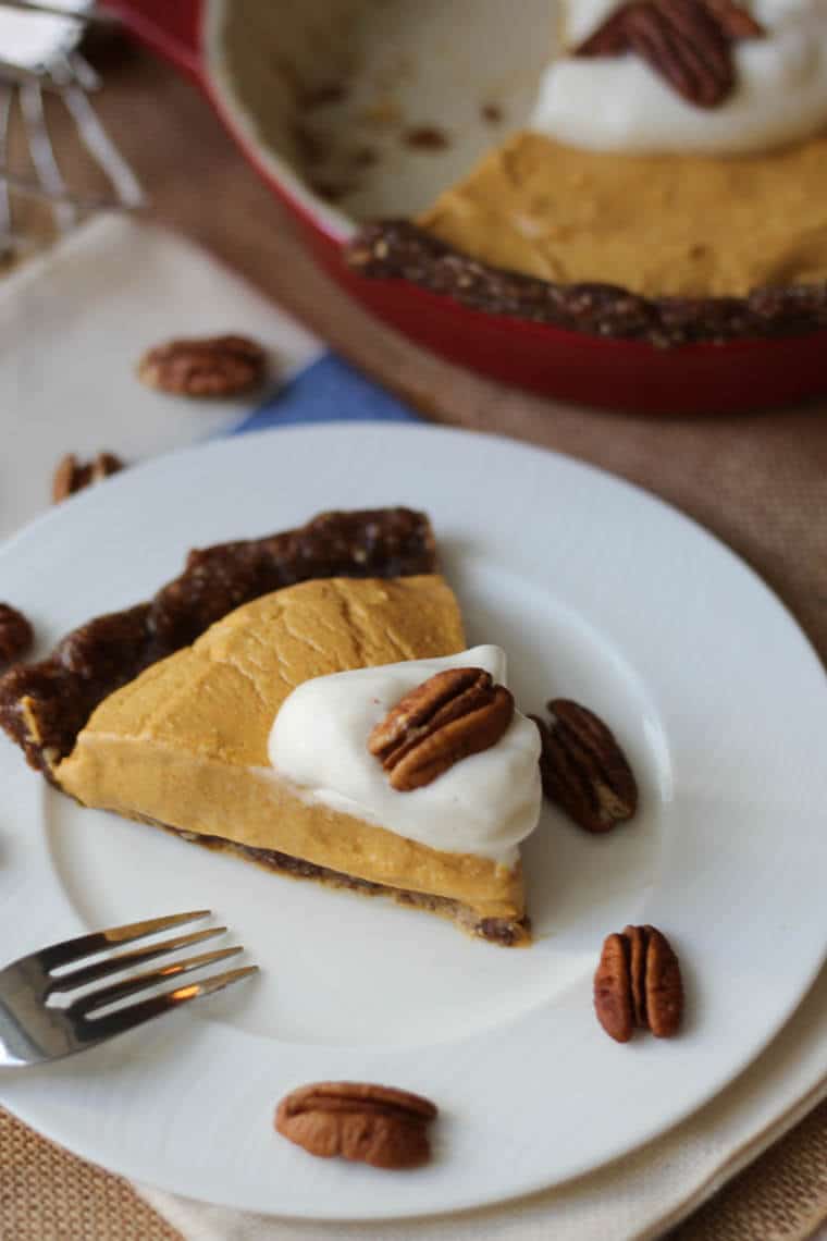 A close up of a slice of pumpkin pie on a plate.