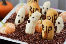 An edible graveyard made with bananas with ghost faces.