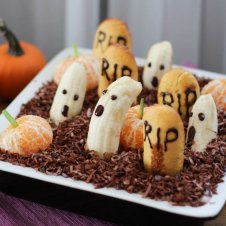 An edible graveyard made with bananas with ghost faces.