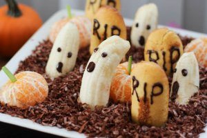 An edible graveyard made with bananas with ghost faces.