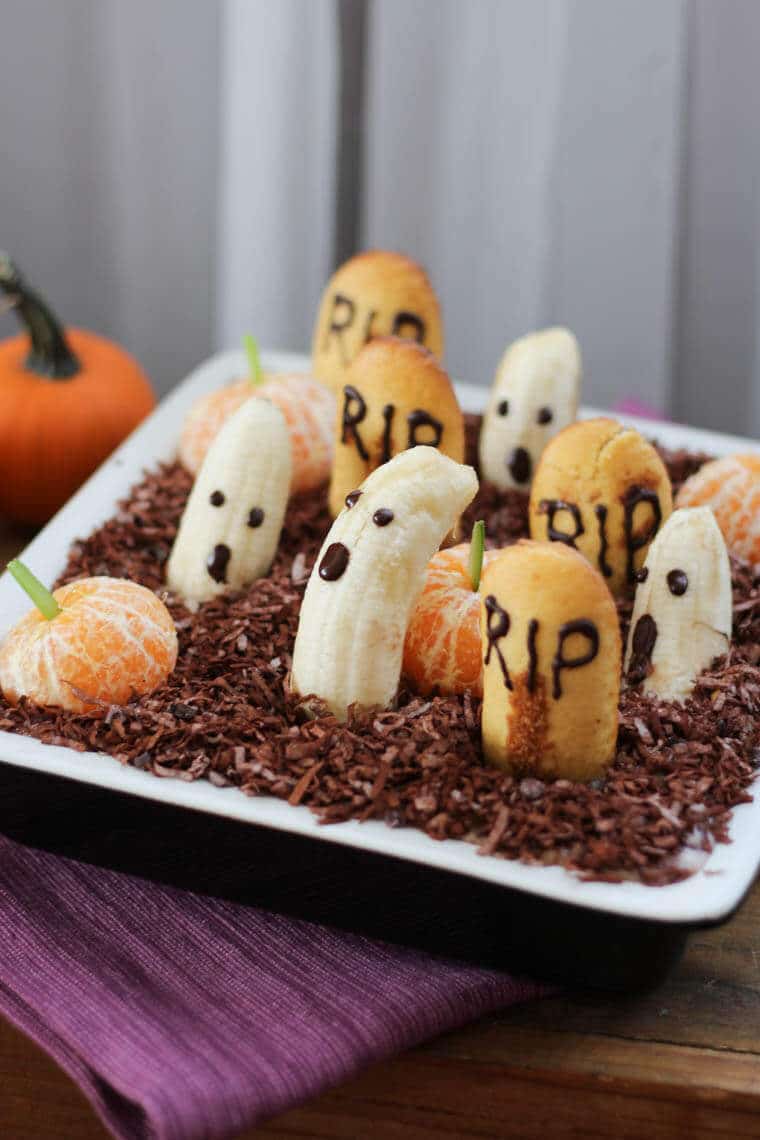 An edible graveyard made with bananas with ghost faces.
