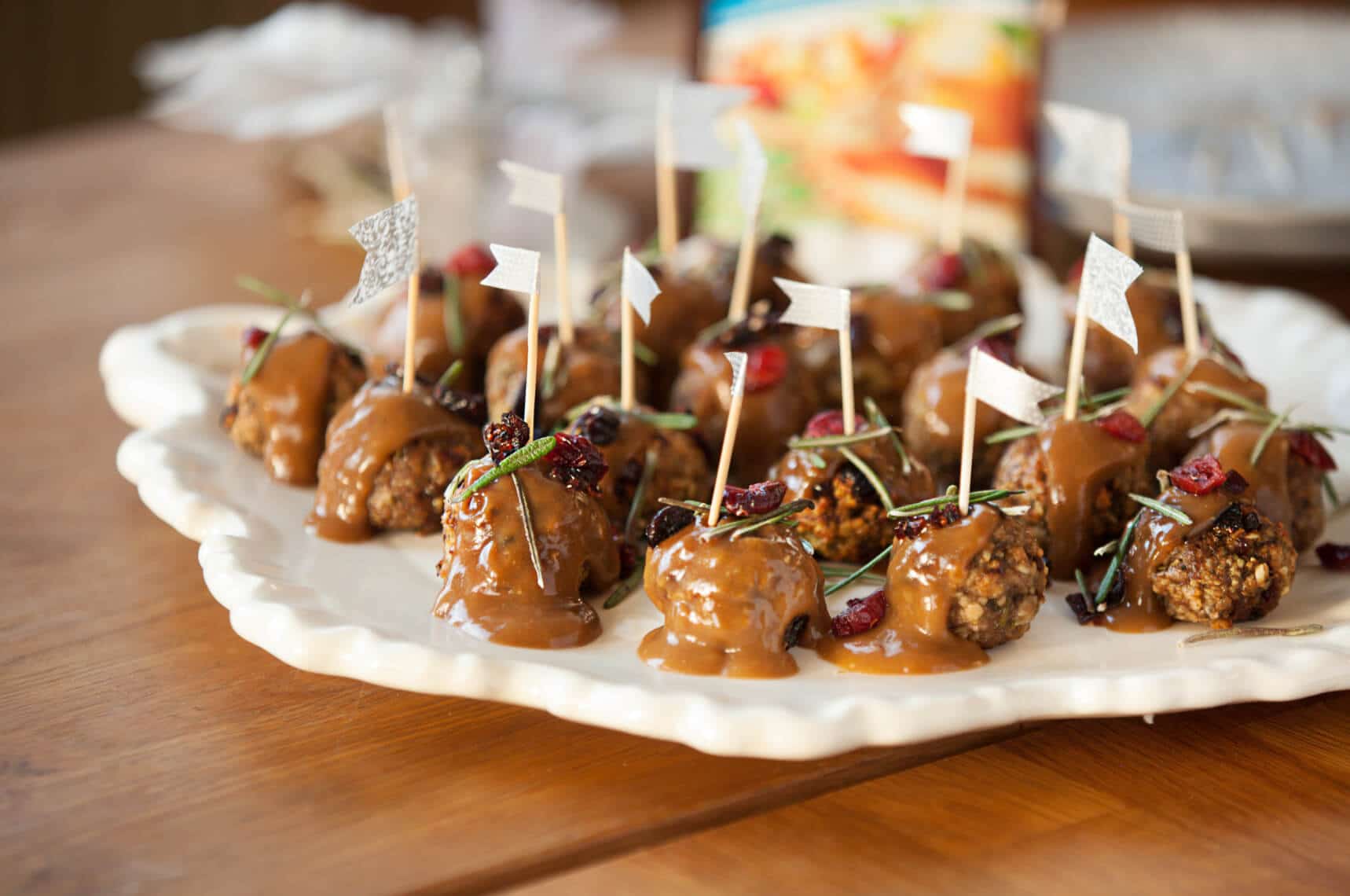 several cranberry flavoured meatballs on a white decorative plate 