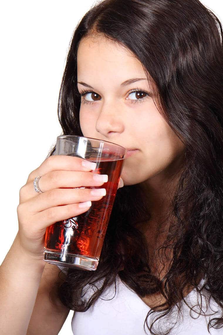woman drinking a red drink for constipation